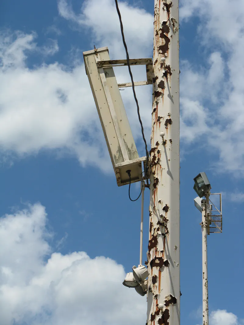 Rust staining and corrosion along an older light pole