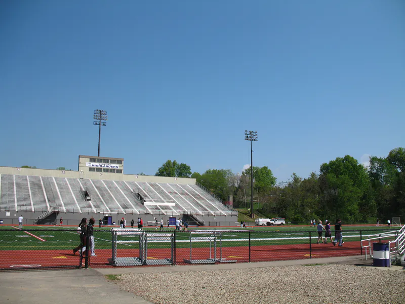 Stadium light towers standing above a running track and grandstand