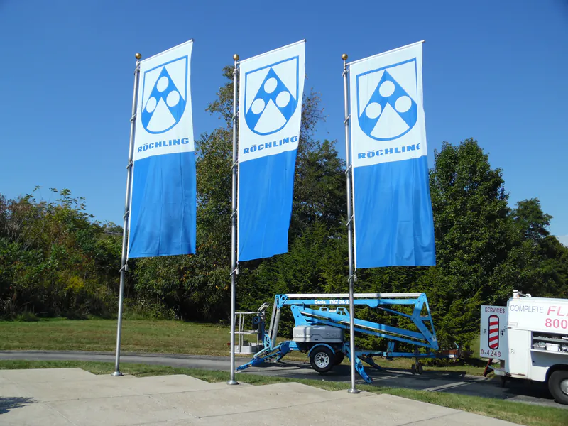 Three corporate banner flagpoles with the towable lift still in position