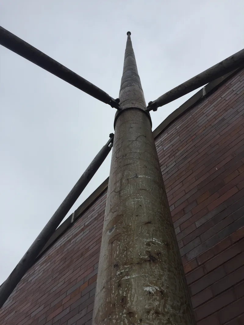 Rooftop mast and stay wires above a commercial building